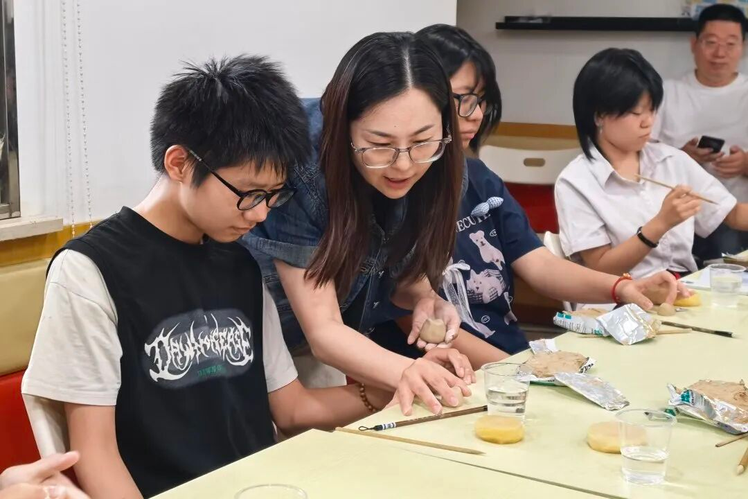 高老师悉心指导青少年进行揉泥、塑形、雕刻等基础工序
